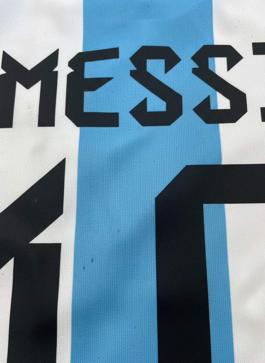 SMUG Argentina youth soccer jersey featuring Messi name and number 10 in black on sky blue and white striped fabric.